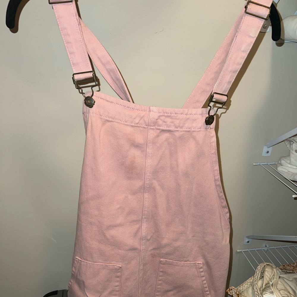 Pink overall dress. Super cute with a bralette and pair of cowboy boots!